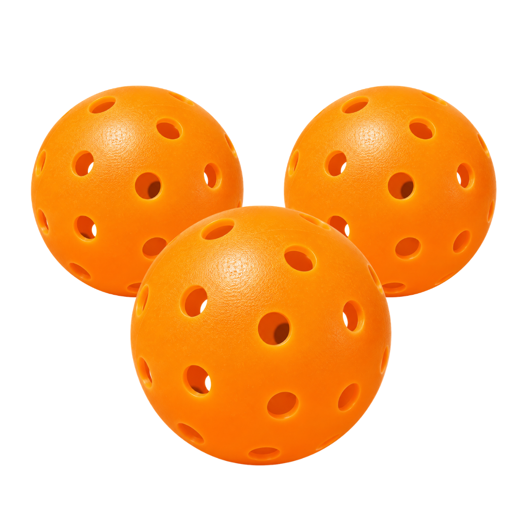 Three orange Slash outdoor pickleballs grouped together